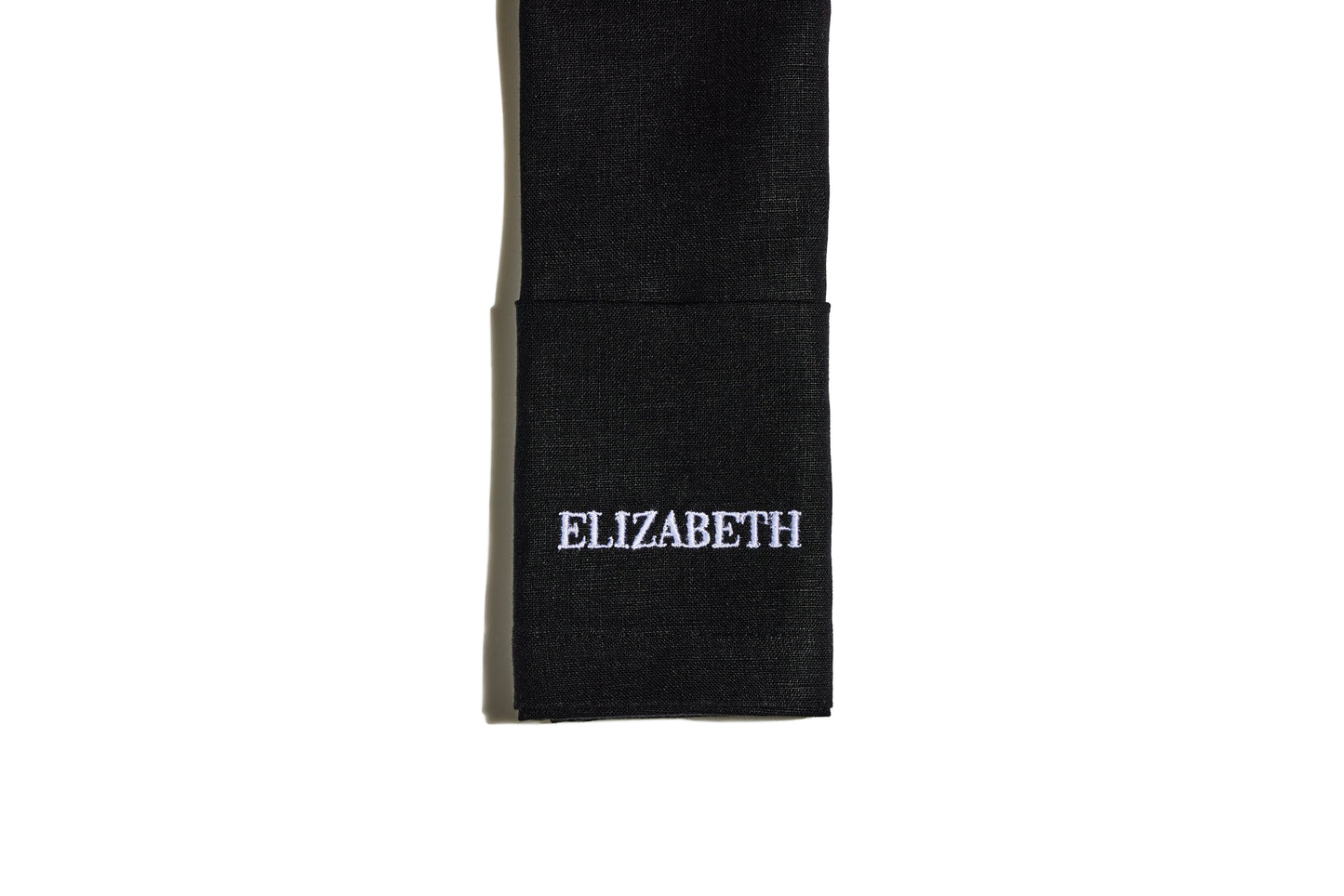 Black linen napkin with white embroidered name Elizabeth in block capitals
