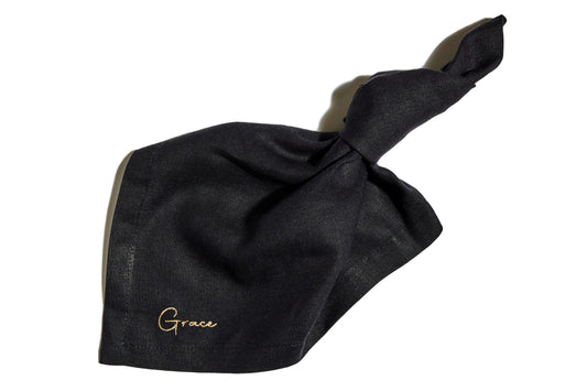 Embroidered black linen napkin with guest name in gold thread